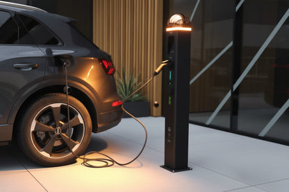 Electric car charging station with a car plugged in, against a dark background.